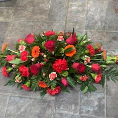Red and orange casket spray