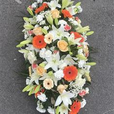 Orange, peach and white casket spray 
